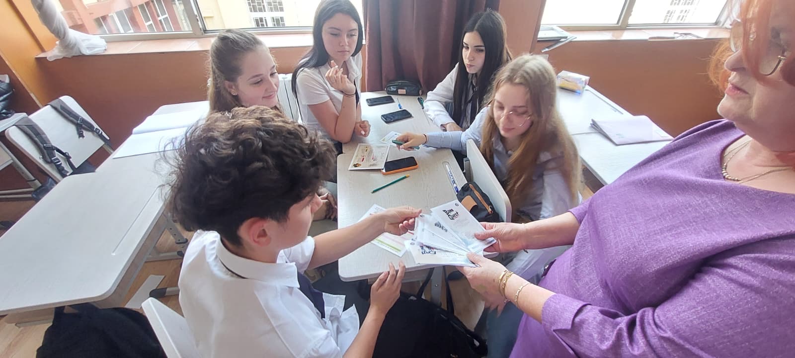 Profesoară împărțind cartonașele jocului