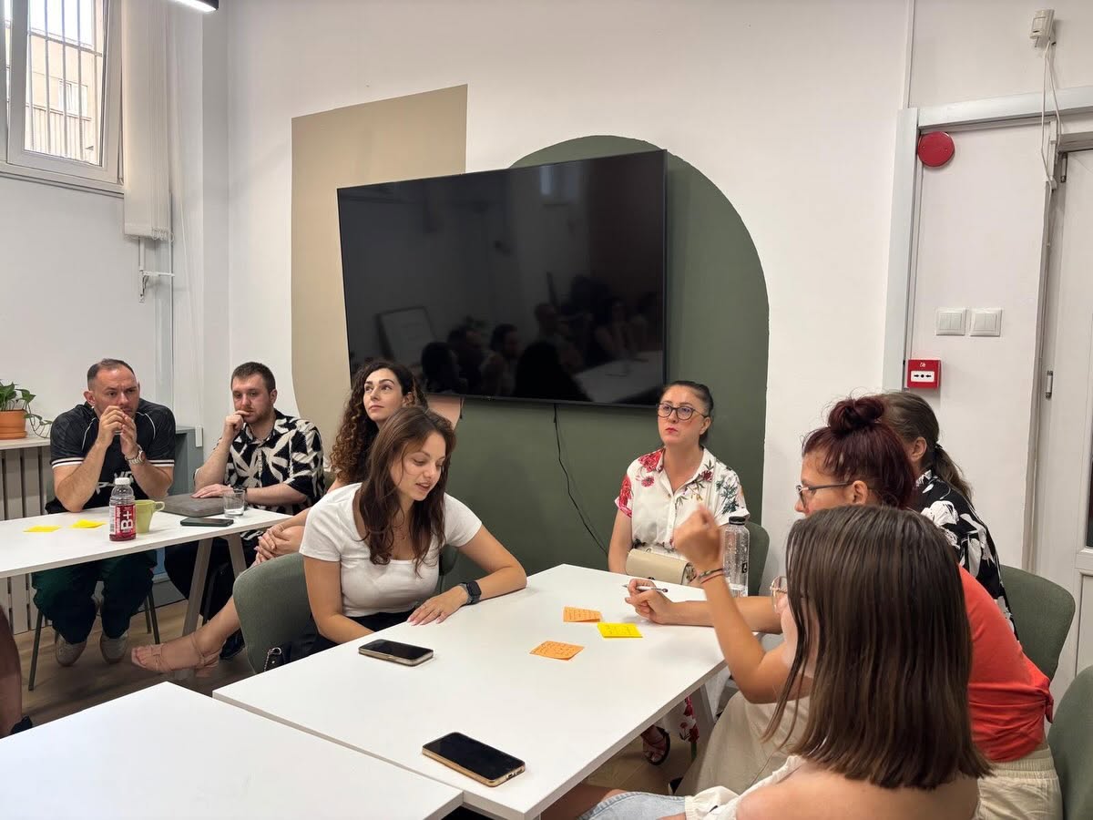 Participanți în conversație, cu notițe pe post-it-uri pe masă